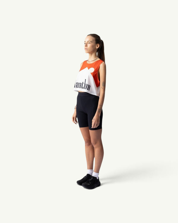 Participation Marathon red and white crop singlet on a model wearing black bike shorts, side profile view.