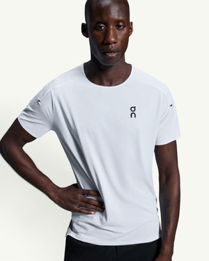 On men's white performance running t-shirt with technical moisture-wicking fabric and athletic fit on a model