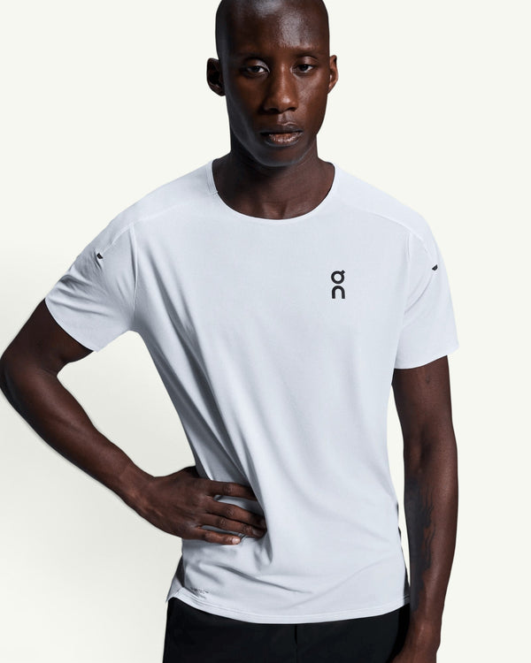 On men's white performance running t-shirt with technical moisture-wicking fabric and athletic fit on a model