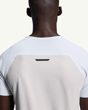 Back view of a man wearing an On white performance running t-shirt with technical mesh fabric and ventilation
