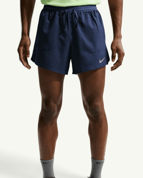 Nike ACG men's navy blue 5-inch 2-in-1 running shorts with reflective trim and inner liner on a model