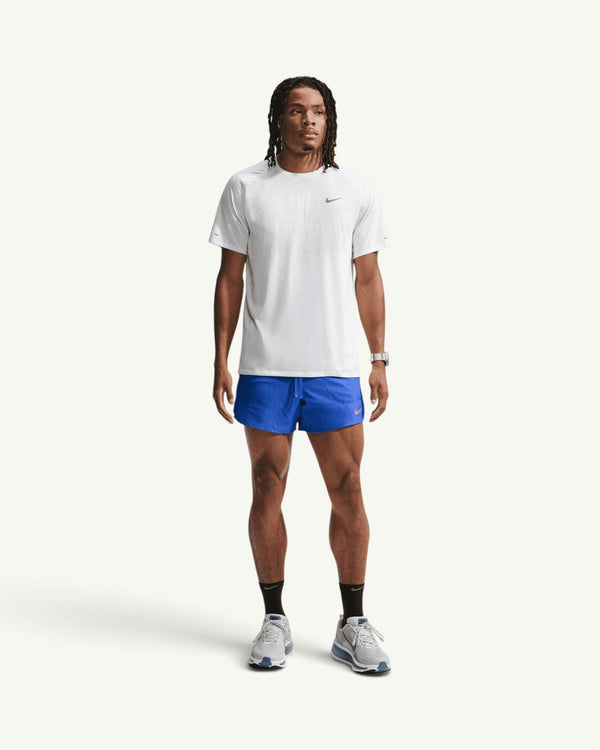 Amateur model wearing blue Nike Stride 5-inch brief-lined training shorts and a white performance t-shirt