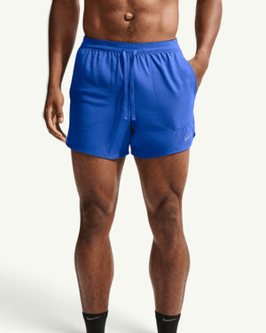 Amateur men's blue Nike Stride 5-inch training shorts with a brief liner and reflective details on a runner