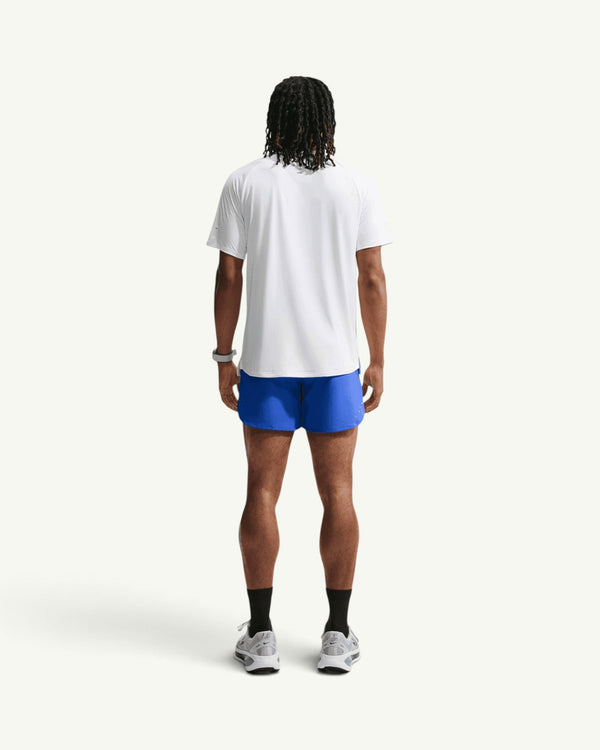 Nike men's blue 5-inch stride training shorts with brief liner worn by a model from the back view
