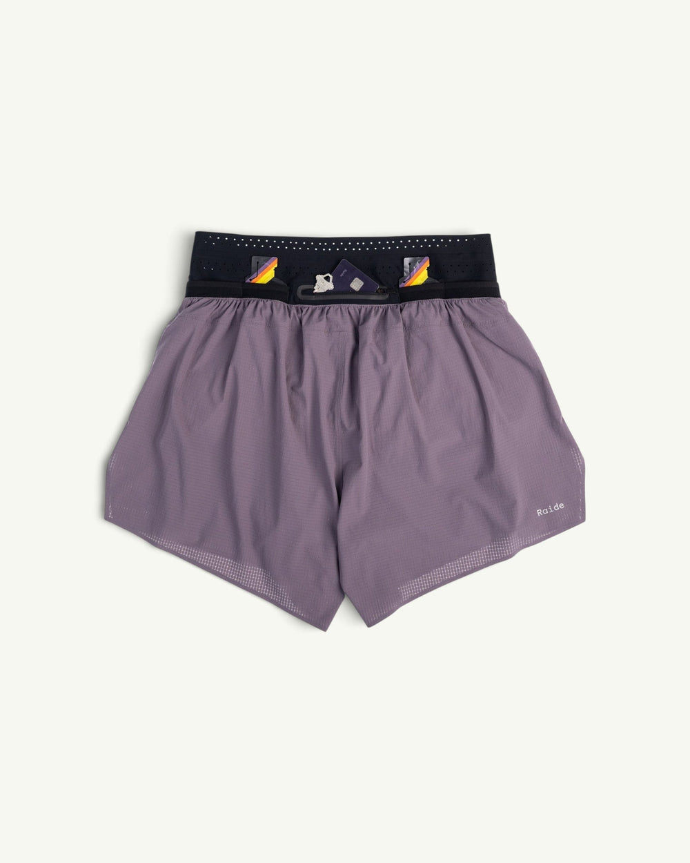 Raide Men's TrailTech 5-inch mountain running shorts in purple with a black waistband and reflective logo detail.