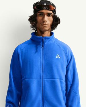 Nike ACG WOLF TREE full-zip fleece jacket in bright blue with a high collar and chest logo, worn by a model.
