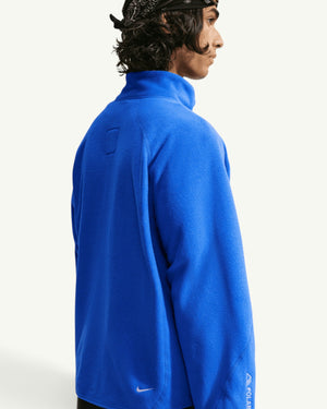 Nike ACG Wolf Tree full-zip jacket in bright blue Polartec fleece worn by a model from the side view.