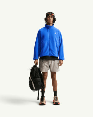 Nike ACG WOLF TREE FULL-ZIP JACKET in bright blue Polartec fleece worn by a model with a black backpack