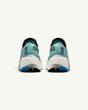 On Women's Cloudboom Volt racing shoes in light blue with white Helion HF foam soles, rear view.