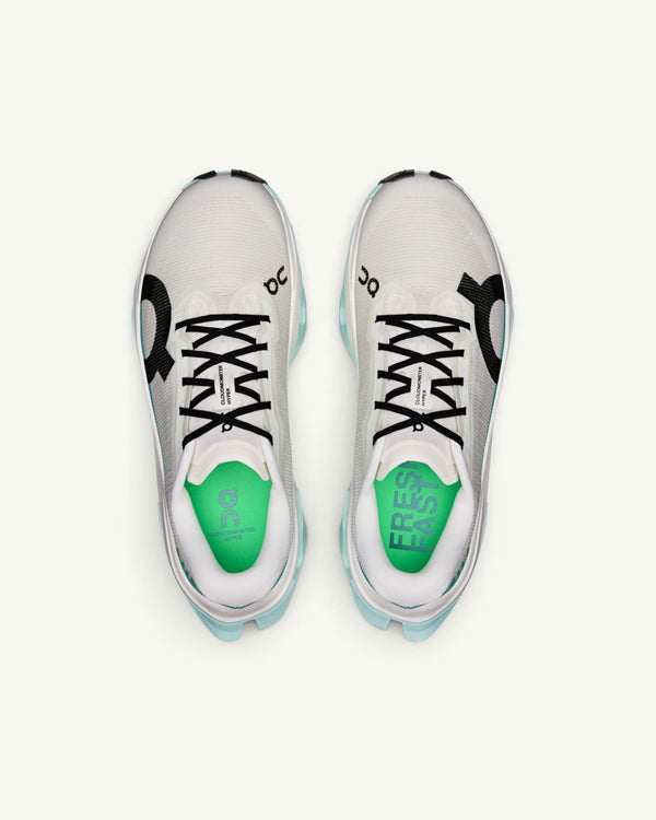 On Women's Cloudmonster 3 Hyper running shoes in white with black accents and bright green insoles, top view.