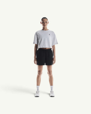 On Women's Club boxy-fit grey cotton-blend t-shirt worn with black athletic shorts and white sneakers