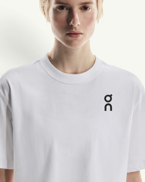 On women's white boxy-fit cotton-blend t-shirt with a black logo on the chest worn by a model