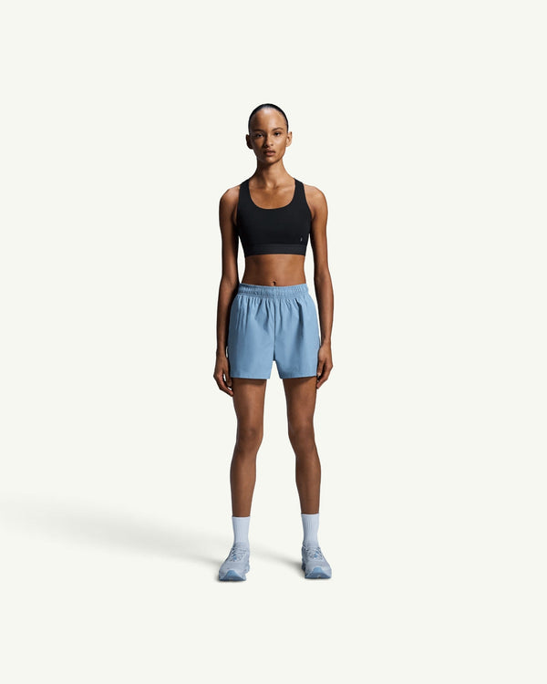 On Women's Core Bra in black, a soft, seam-minimal sports bra for light-to-medium support on a female model.