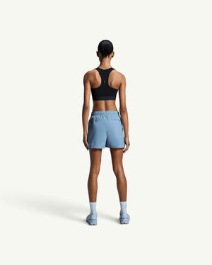 On Women's Core Bra in black with a racerback design, worn by a model from the back view.