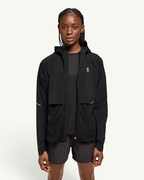 On women's core jacket in black, a lightweight wind-blocking and water-resistant hooded running shell.