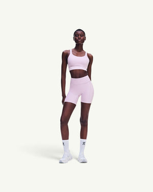 On women's performance bra in light pink, featuring a breathable, chafe-free design for high-intensity workouts.