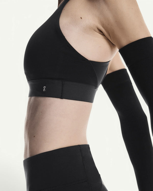 On women's black performance bra with a chafe-free design and breathable stretch fabric, side view.