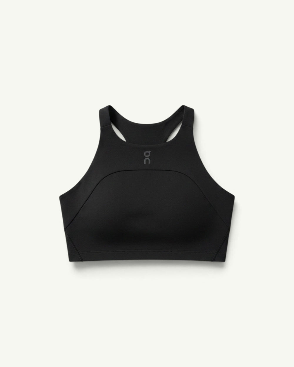 On women's black performance crop top with a high neckline and racerback design for running and training.