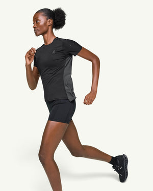 On women's black performance running t-shirt with technical fabric and ventilation panels on a female runner.