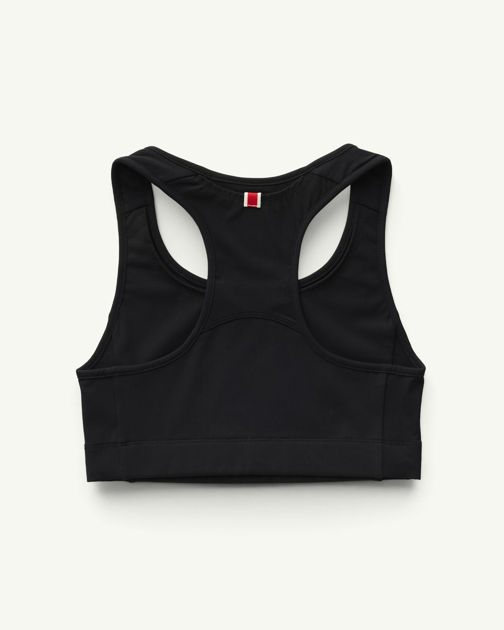 Amateur Tracksmith Allston sports bra in black with a gold hare logo, featuring a supportive racerback design.