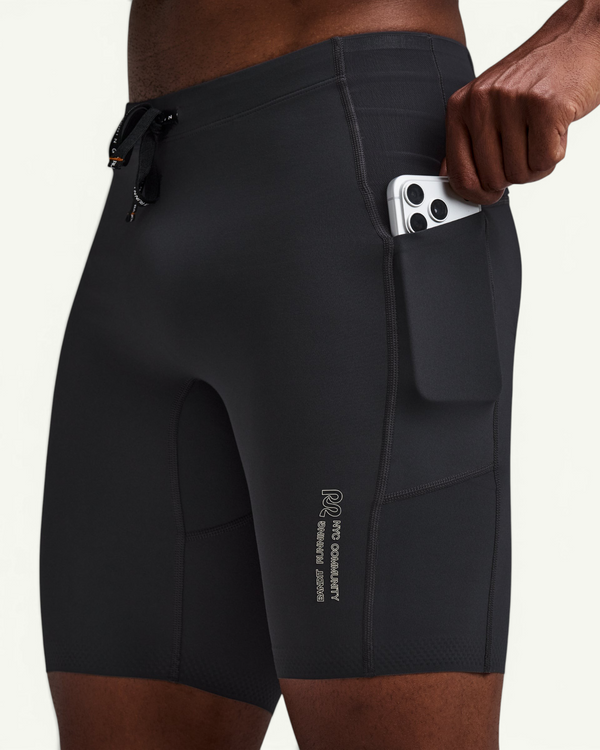 Amateur black compression half tights with a side pocket holding a smartphone, designed for running performance.