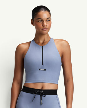 Amateur women's blue ribbed zip-front race crop top with a halter T-back design and built-in bra support.