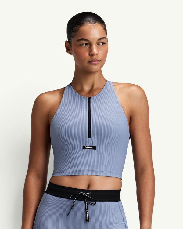 Amateur women's blue ribbed zip-front race crop top with a halter T-back design and built-in bra support.