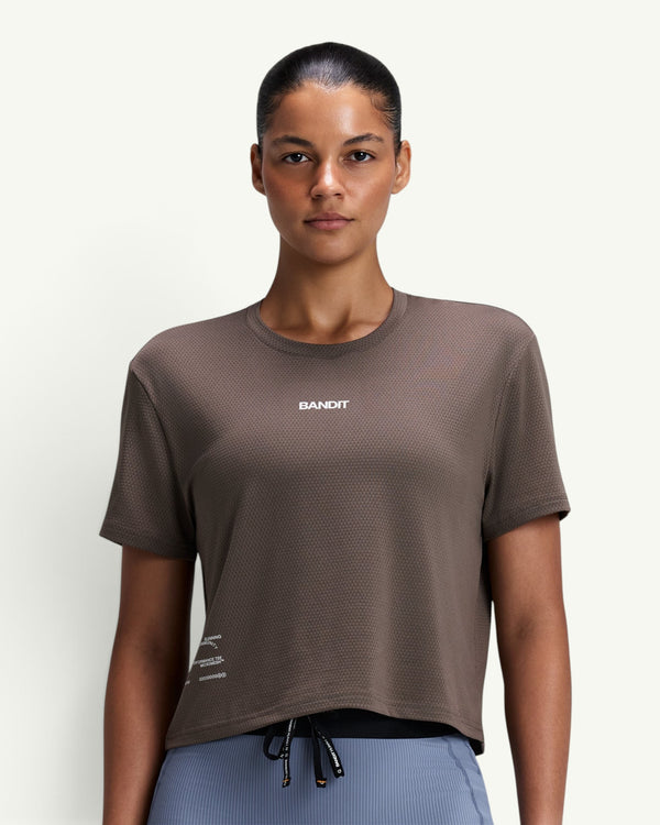 Amateur women's brown Micromesh cropped run tee with crew neck, boxy fit, and reflective branding on a model