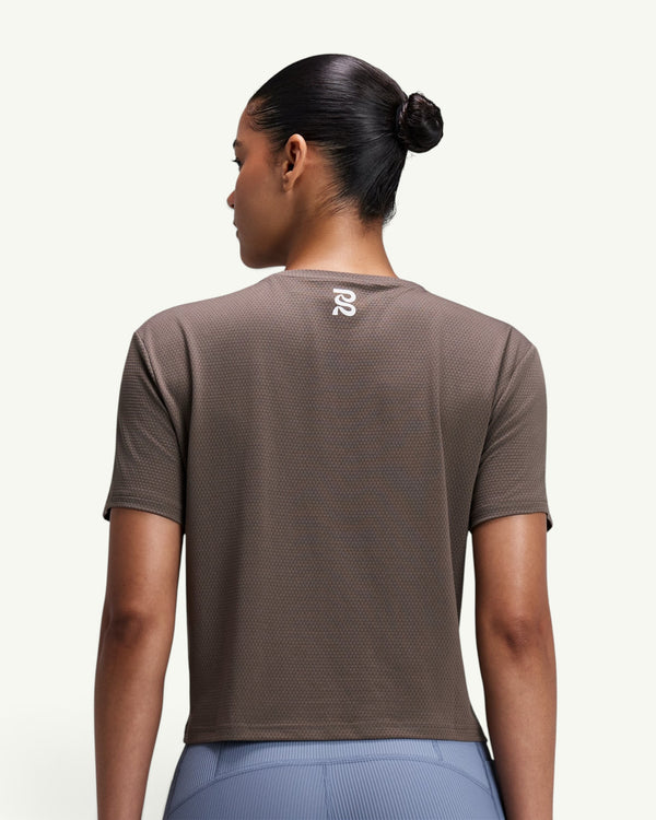 Amateur women's brown micromesh cropped run tee with a crew neck and reflective logo, shown from the back.