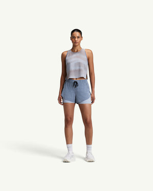 Amateur women's CoolGrid race singlet in light grey with a sheer shadow-stripe knit, worn by a model with blue shorts.