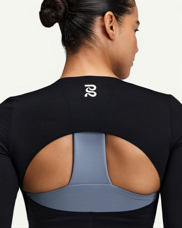 Amateur black GeoMesh long sleeve training top featuring a half-moon back cutout revealing a blue T-back sports bra