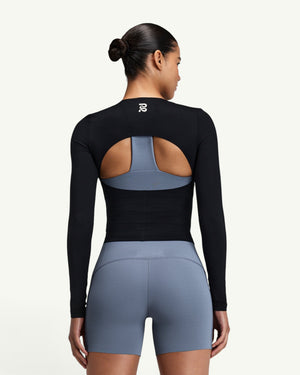 Amateur black GeoMesh long sleeve training top with a half-moon back cutout, worn over a blue sports bra.