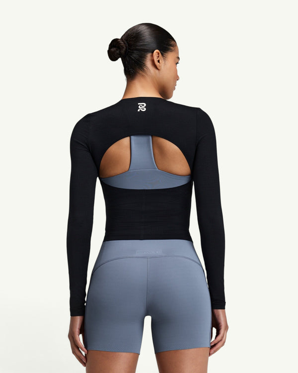 Amateur black GeoMesh long sleeve training top with a half-moon back cutout, worn over a blue sports bra.
