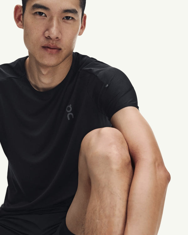 Amateur men's black performance running t-shirt in technical fast-drying fabric with athletic fit on a male model