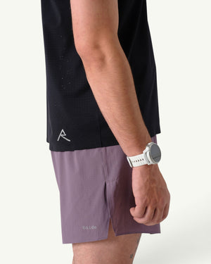 Amateur men's black thermal dispersion trail tee with perforated fabric, worn with purple shorts and a white watch.