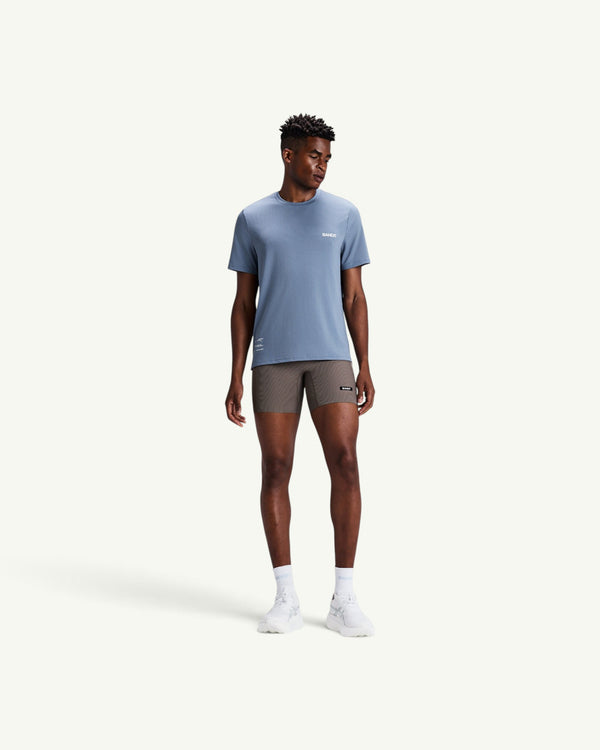 Amateur men's blue Micromesh run tee with crew neck and reflective details worn by a male model with athletic shorts