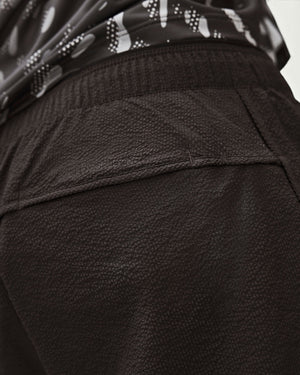 Close-up of Amateur Men's Performance Volt shorts in black, featuring lightweight, textured, ventilated fabric.