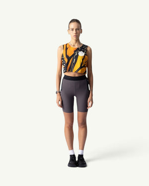 Participation Monarch crop singlet featuring orange and black butterfly wing print, worn by a runner in grey bike shorts.