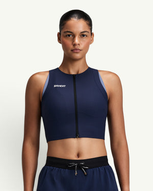 Amateur women's navy blue Adapto 2-way zip race crop top with compression fit and front zipper on a female model