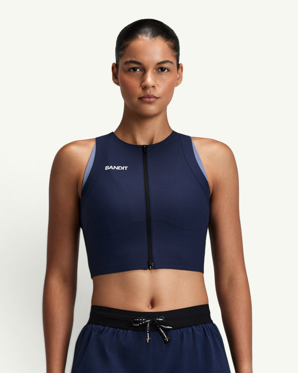 Amateur women's navy blue Adapto 2-way zip race crop top with compression fit and front zipper on a female model
