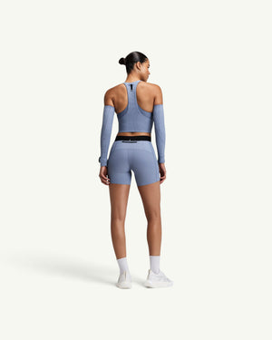 Amateur women's blue ribbed T-back race crop top with zip front and back pocket worn with matching shorts
