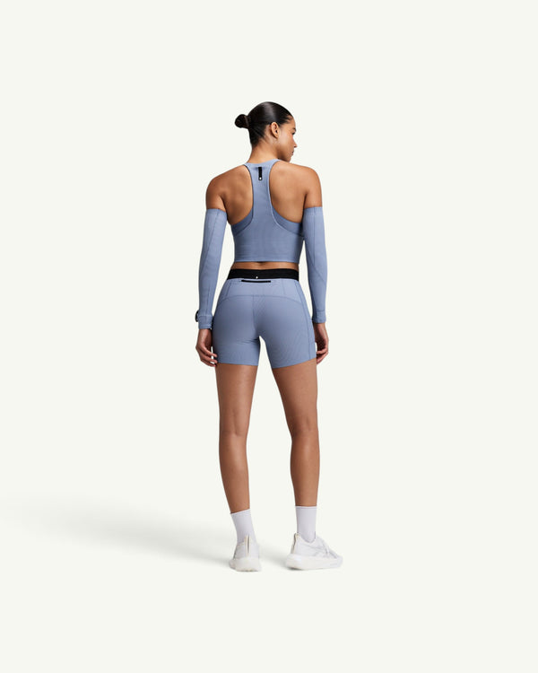 Amateur women's blue ribbed T-back race crop top with zip front and back pocket worn with matching shorts