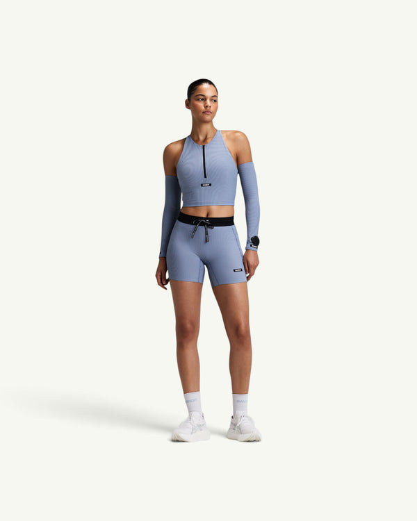 Amateur women's blue striped ribbed zip-front race crop top with T-back design and matching compression shorts.