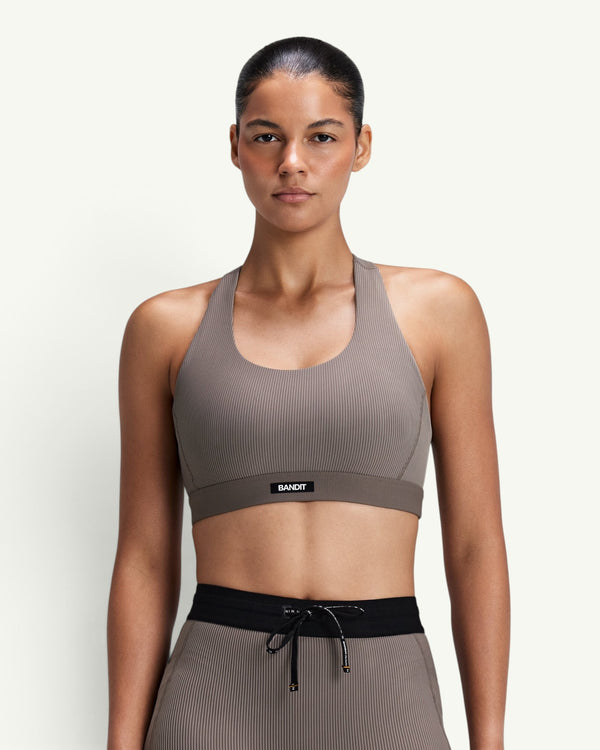 Amateur women's taupe ribbed scoop neck T-back sports bra with compression fit and Bandit logo patch