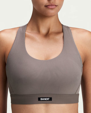 Amateur women's taupe ribbed scoop neck sports bra with T-back racerback design and Bandit logo detail