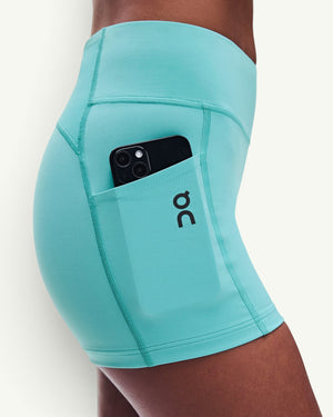 Amateur women's 3-inch performance tights in turquoise with a side pocket holding a smartphone