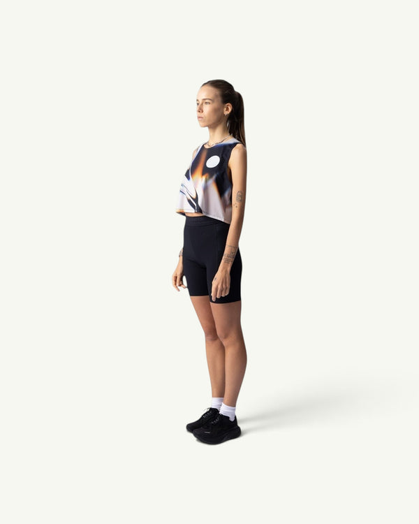 Amateur White Glass crop singlet worn by a female runner in a side profile view, featuring a quick-drying stretch fit.