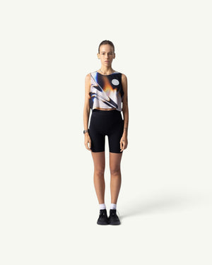 Amateur White Glass crop singlet featuring a metallic abstract print on a runner, paired with black bike shorts.