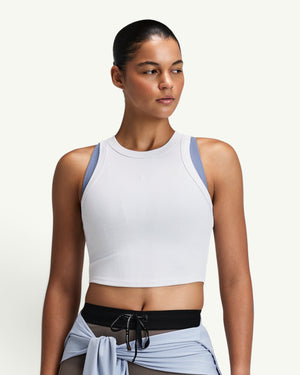 Amateur women's white ribbed performance tank top with a high neck, worn by a model in a studio setting.