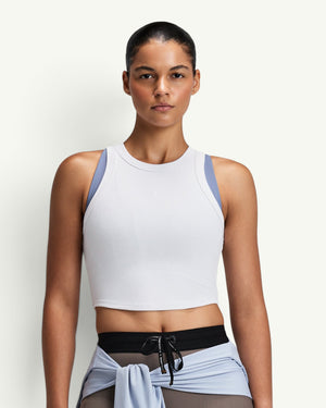 Amateur women's white ribbed performance tank top with a cropped fit and moisture-wicking fabric on a model.